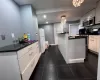 Kitchen featuring white cabinets, pendant lighting, stainless steel appliances, and a chandelier