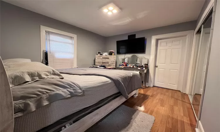 Bedroom with wood-type flooring and a closet