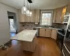 Kitchen featuring stainless steel appliances, sink, hardwood / wood-style flooring, a center island, and hanging light fixtures