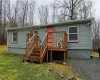 Back of property featuring a deck and a lawn