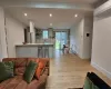 Living room featuring light hardwood / wood-style floors, sink, a wall unit AC, and a baseboard radiator