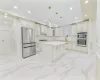 Kitchen featuring decorative backsplash, ornamental molding, stainless steel appliances, decorative light fixtures, and a center island