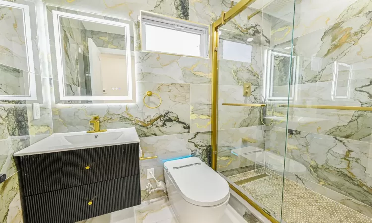 Bathroom with an enclosed shower, vanity, toilet, and tile walls