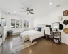 Bedroom with dark hardwood / wood-style floors, ceiling fan, and a baseboard heating unit