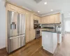 Kitchen featuring backsplash, dark hardwood / wood-style flooring, dark stone counters, and appliances with stainless steel finishes