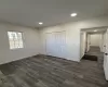 Additional living space with dark hardwood / wood-style flooring, a baseboard radiator, and lofted ceiling