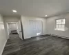 Unfurnished bedroom with a baseboard radiator, a closet, and dark wood-type flooring