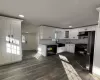 Kitchen with sink, dark wood-type flooring, stainless steel appliances, tasteful backsplash, and white cabinets