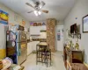 Kitchen featuring white cabinets, ceiling fan, backsplash, and stainless steel refrigerator