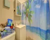 Bathroom with a shower with shower curtain, vanity, and toilet