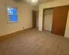 Unfurnished bedroom with a closet, carpet, and a baseboard radiator