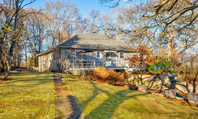 Back of property featuring cooling unit and a yard