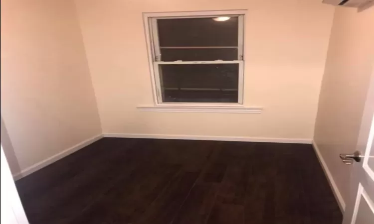 Spare room with dark hardwood / wood-style floors