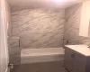 Bathroom with vanity, tiled shower / bath combo, tile patterned floors, and tile walls