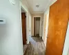 Hallway with dark hardwood / wood-style flooring and crown molding