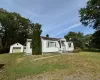 View of front of house with a garage, a front lawn, and an outdoor structure