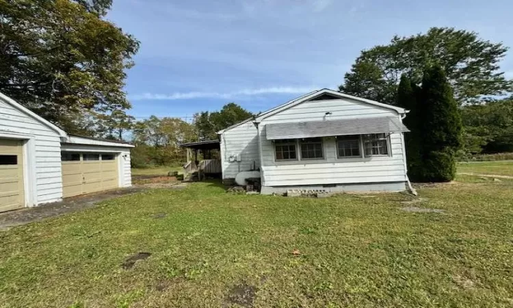 View of home's exterior featuring an outbuilding, a yard, and a garage