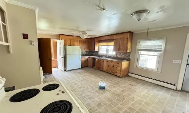 Kitchen featuring white appliances, ceiling fan, decorative backsplash, ornamental molding, and baseboard heating