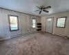 Carpeted entrance foyer featuring ceiling fan and a baseboard heating unit