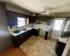 Kitchen with decorative backsplash, dark brown cabinets, ceiling fan, sink, and a baseboard radiator