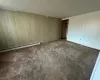 Carpeted empty room featuring a baseboard heating unit