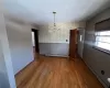 Unfurnished dining area featuring hardwood / wood-style floors, a chandelier, and a baseboard radiator