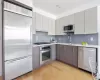 Kitchen featuring gray cabinets, light hardwood / wood-style flooring, stainless steel appliances, and sink