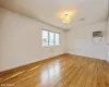 Empty room with light hardwood / wood-style floors and a wall mounted AC