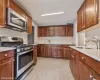 Kitchen with light stone countertops, appliances with stainless steel finishes, backsplash, and sink