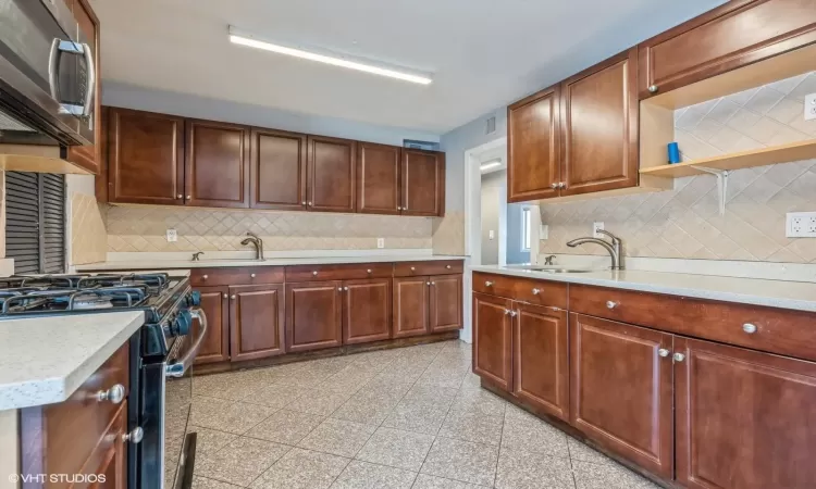 Kitchen with decorative backsplash, stainless steel appliances, and sink