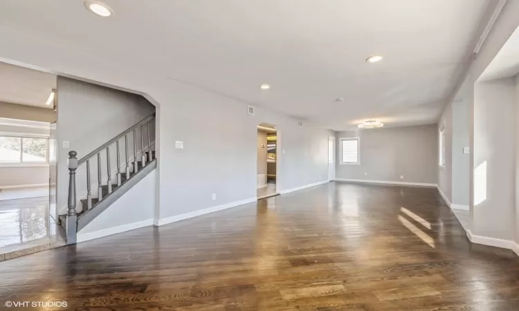 Empty room featuring plenty of natural light and dark wood-type flooring