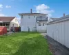 Back of property featuring a balcony and a yard