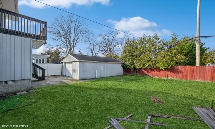 View of yard with a garage and an outbuilding