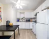 Kitchen featuring white appliances, ceiling fan, sink, light hardwood / wood-style flooring, and white cabinets