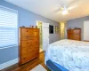 Bedroom with connected bathroom, dark hardwood / wood-style floors, and ceiling fan