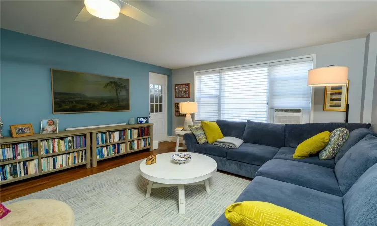 Living room featuring ceiling fan, cooling unit, and hardwood / wood-style flooring