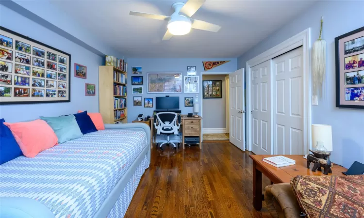 Bedroom with a closet, ceiling fan, and dark hardwood / wood-style flooring