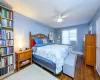 Bedroom with ceiling fan, radiator heating unit, and dark hardwood / wood-style floors