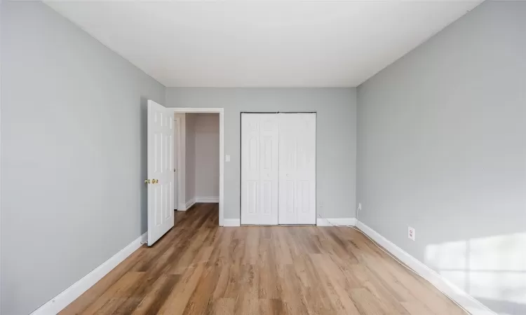 Unfurnished bedroom with hardwood / wood-style floors and a closet