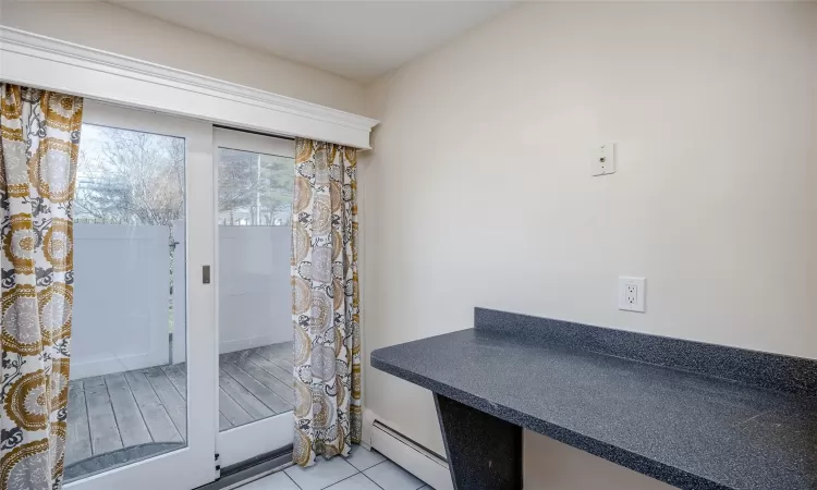 Doorway with light tile patterned floors and a baseboard radiator