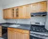 Kitchen with tasteful backsplash, stainless steel gas range oven, sink, and black dishwasher