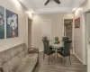 Living room with hardwood / wood-style floors, a raised ceiling, and ceiling fan