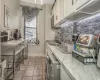 Kitchen with sink, tasteful backsplash, washer / dryer, white cabinetry, and stainless steel appliances