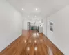 Unfurnished living room featuring sink, light hardwood / wood-style floors, and lofted ceiling