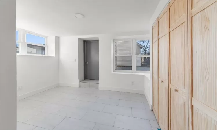 Unfurnished bedroom with light tile patterned flooring and a closet