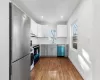 Kitchen featuring gray cabinetry, stainless steel appliances, sink, hardwood / wood-style floors, and white cabinetry