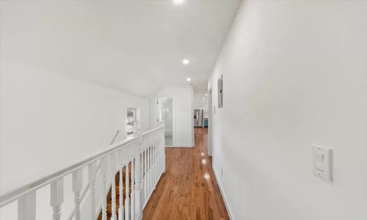 Hall with hardwood / wood-style floors and lofted ceiling