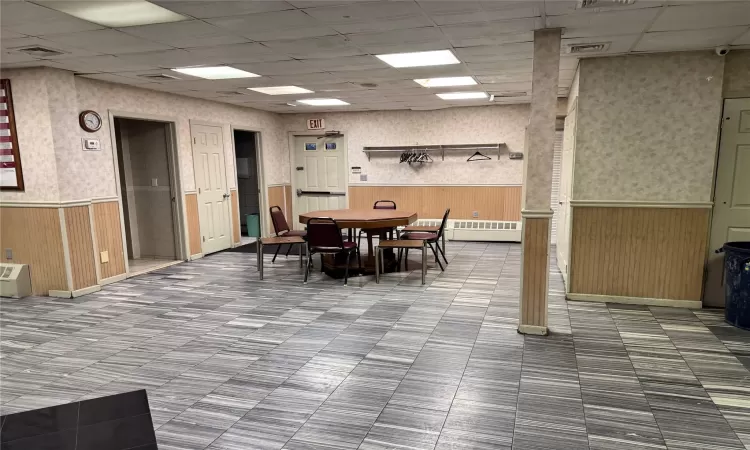 Dining room with a drop ceiling and wood walls