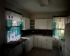 Kitchen featuring white appliances, backsplash, white cabinetry, and sink