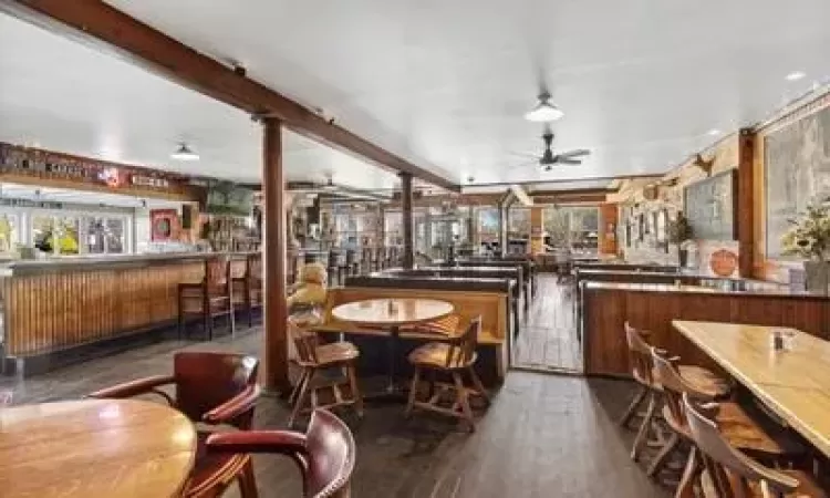 Bar featuring dark hardwood / wood-style floors and ceiling fan